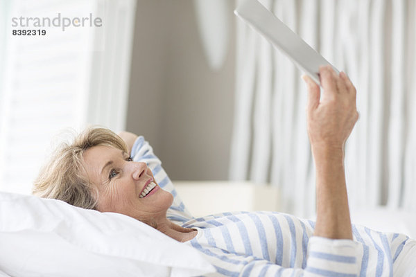 Ältere Frau mit digitalem Tablett