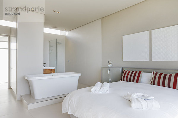 Bett und Badewanne im modernen Schlafzimmer