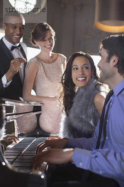 Gut gekleidete Freunde spielen Klavier in einem luxuriösen Nachtclub.