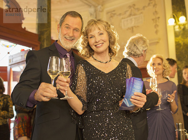 Porträt eines gut gekleideten Paares mit Champagnerflöte in der Theaterlobby