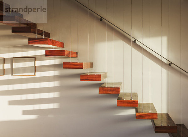 Schatten auf schwimmender Treppe im modernen Haus
