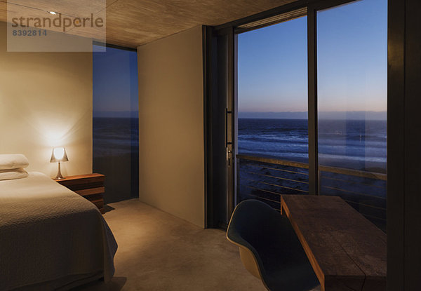 Modernes Schlafzimmer mit Blick auf das Meer in der Abenddämmerung