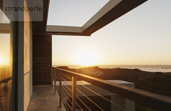 Balkon eines modernen Hauses mit Blick auf das Meer bei Sonnenuntergang