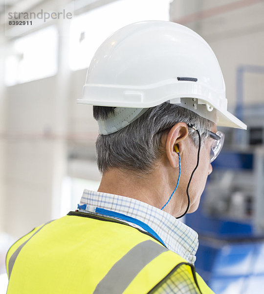 Arbeiter mit Schutzhelm und Gehörschutzstöpseln