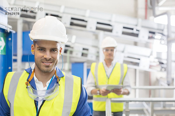 Arbeiter lächeln in der Fabrik