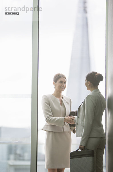 Geschäftsfrauen beim Händeschütteln im Büro