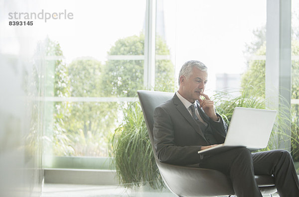 Geschäftsmann mit Laptop in der Lobby