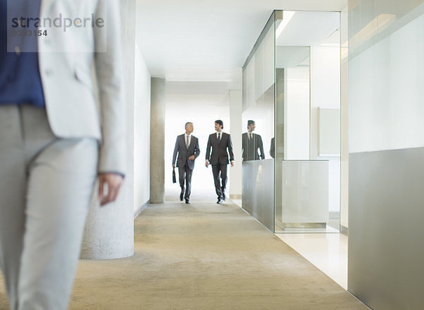 Geschäftsleute  die im Büroflur spazieren gehen