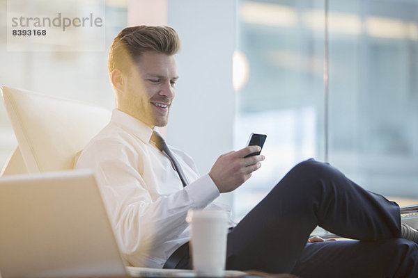 Geschäftsmann mit Handy im Büro