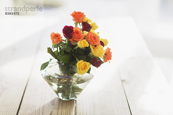 Nahaufnahme von mehrfarbigen Rosen in Vase auf Tisch