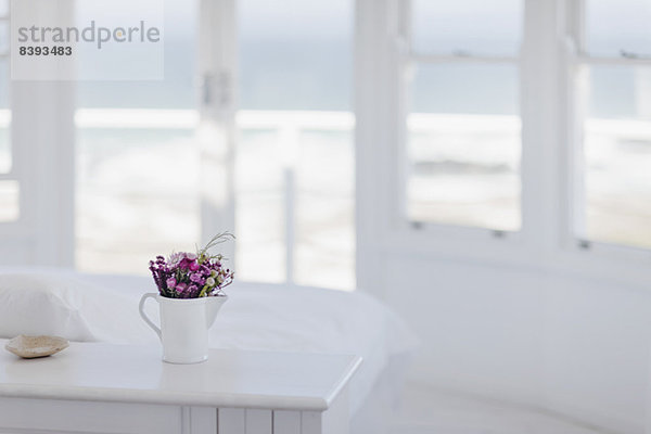 Blumenvase auf dem Schreibtisch im Schlafzimmer mit Blick auf den Ozean