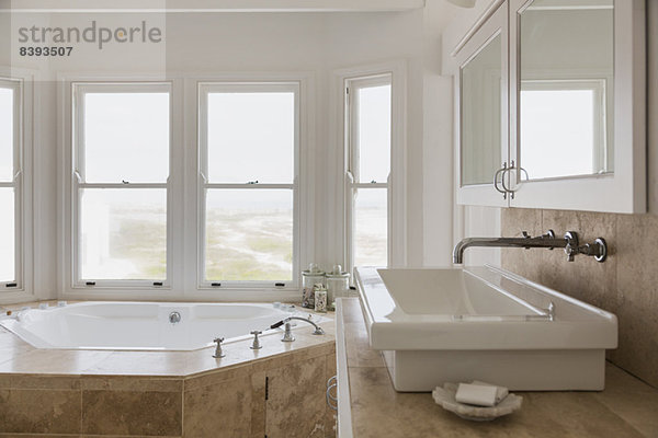 Waschbecken und Whirlpool im luxuriösen Hauptbadezimmer