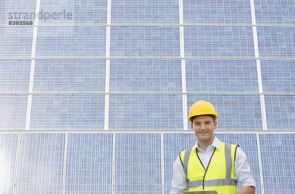 Arbeiter steht im Schatten der Windkraftanlage