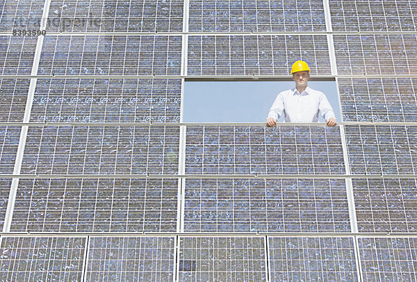 Arbeiter untersucht Solarmodul in ländlicher Landschaft