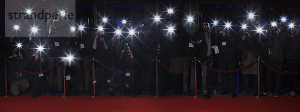 Paparazzi mit Blitzfotografie entlang des roten Teppichs