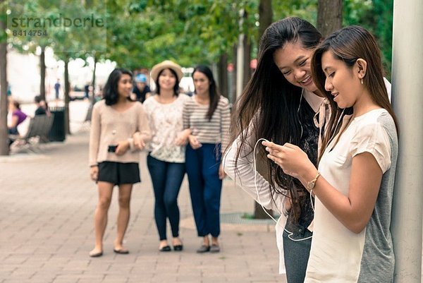 Frauen schauen auf Technik  Freunde kommen