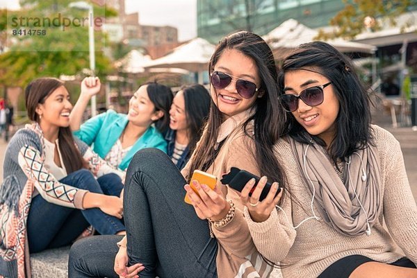 Junge Frauen schauen auf Smartphones