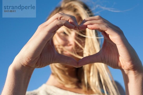 Junge Frau macht Herzschild mit Händen  Breezy Point  Queens  New York  USA