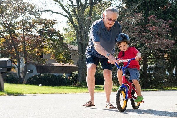 Großvater ermutigt kleinen Jungen zum Radfahren