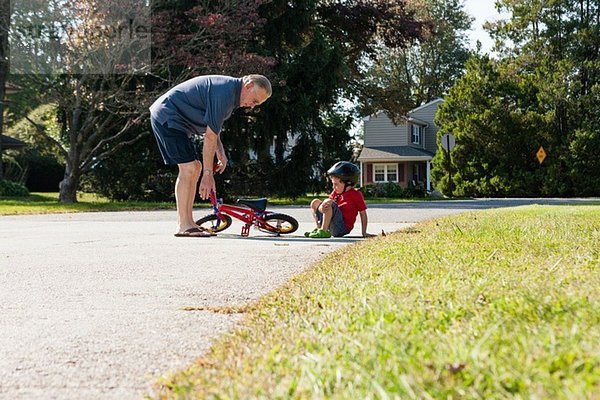 Großvater holt Fahrräder für kleine Jungen ab.
