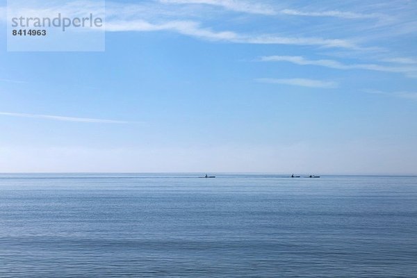 Drei Seekajaker am Horizont  Poole  Dorset  UK