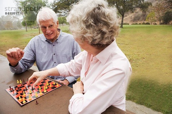 Mann und Frau beim Schachspiel im Park