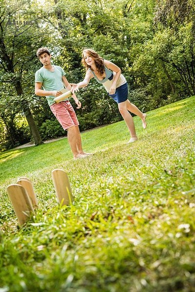 Junges Paar spielt Molkky im Park