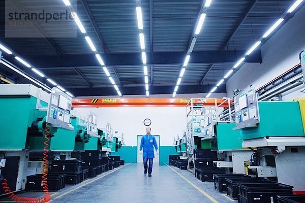 Arbeiter geht durch die Kleinteilefabrik in China