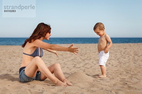 Schwangere Frau am Strand mit offenen Armen für Kleinkinder