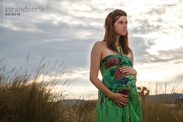 Schwangere Frau im Feld stehend