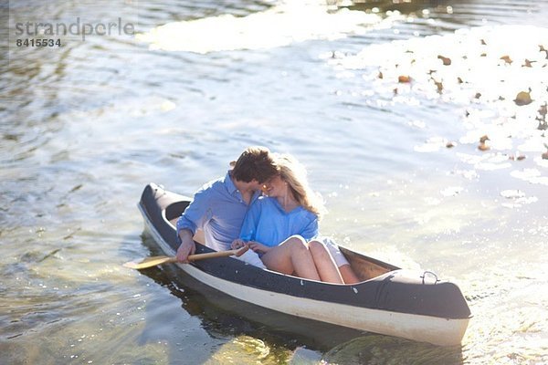 Junges romantisches Paar im Ruderboot auf dem Fluss