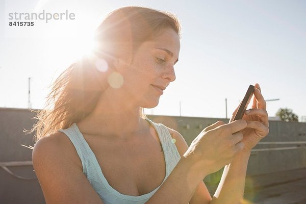 Porträt einer jungen Frau beim Blick aufs Handy