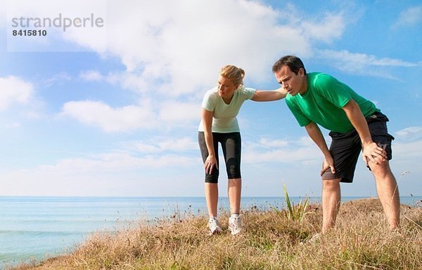 Mittleres erwachsenes Paar  das eine Pause vom Training macht  Thurlestone  Devon  UK