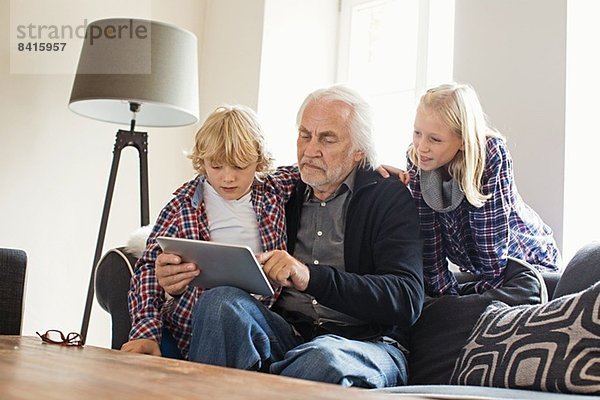 Großvater mit digitalem Tablett mit Enkelkindern