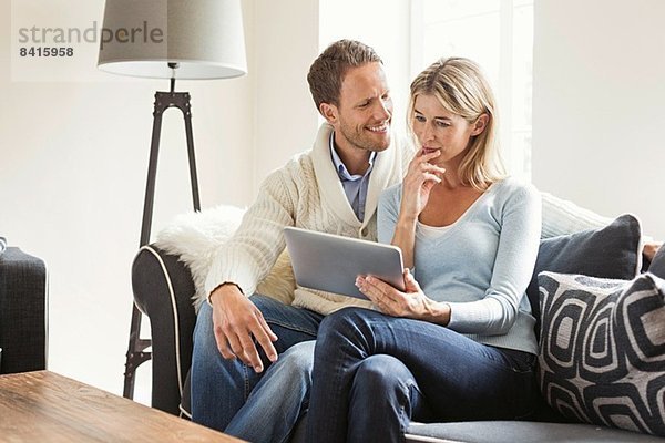 Mittleres erwachsenes Paar mit digitalem Tablett