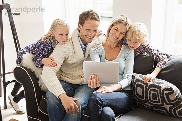 Eltern mit zwei Kindern mit digitalem Tablett