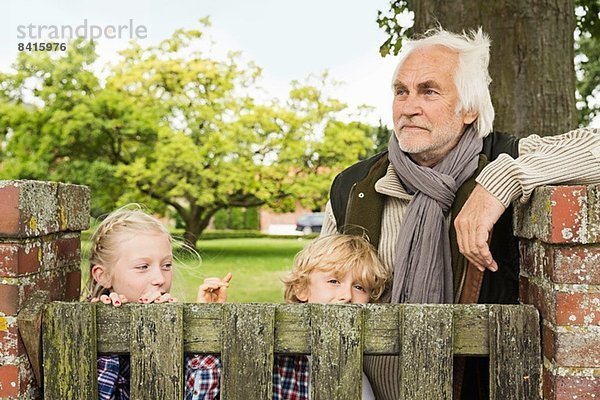 Großvater und Enkelkinder durch Holztor