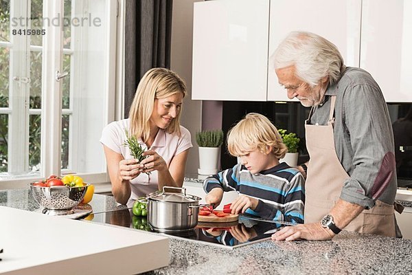 Drei Generationen Familie bei der Zubereitung von Speisen