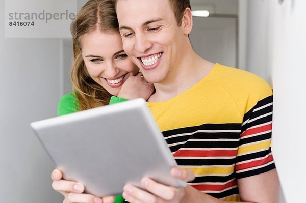 Paar mit digitalem Tablett  lächelnd