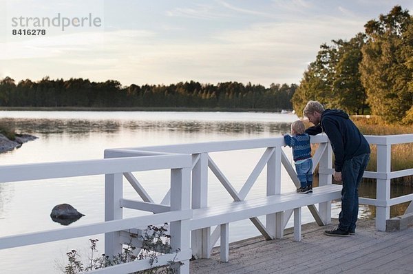 Vater und Sohn schauen auf den See