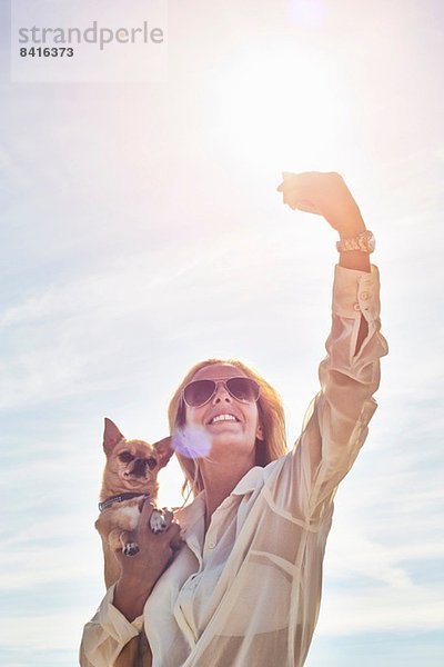 Junge Frau fotografiert sich mit Hund