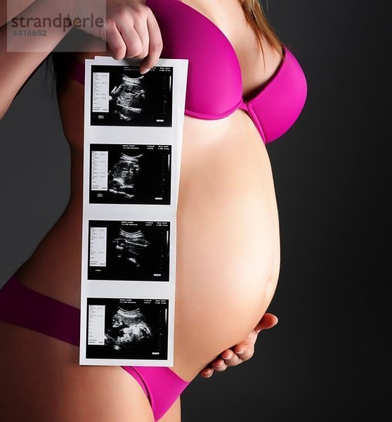 Schwangere Frau mit Ultraschallbildern