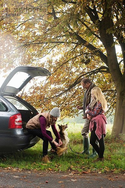Familie und Hund bereiten sich auf einen Spaziergang vom Kofferraum aus vor  Norfolk  UK