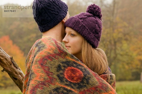 Nahaufnahme eines jungen Paares in Decke gehüllt im Nebelpark