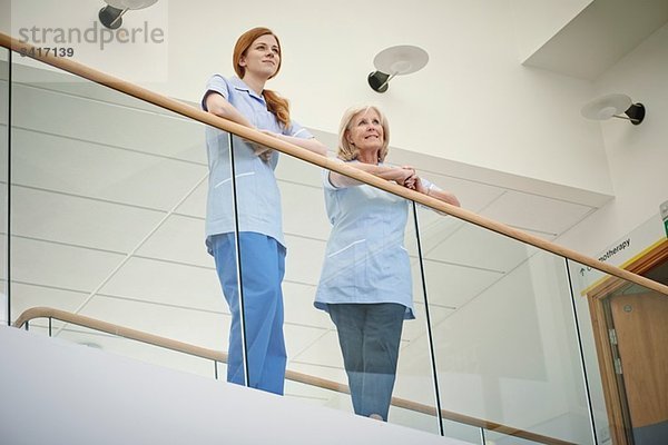 Zwei Krankenschwestern warten auf dem Atrium-Balkon des Krankenhauses.