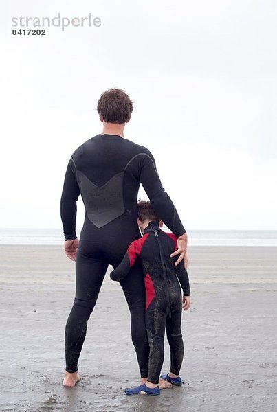 Portrait von Vater und Sohn am Strand  Rückansicht