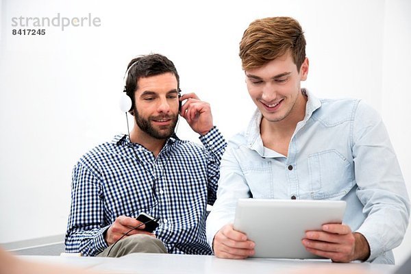 Zwei männliche Kollegen mit digitalem Tablett