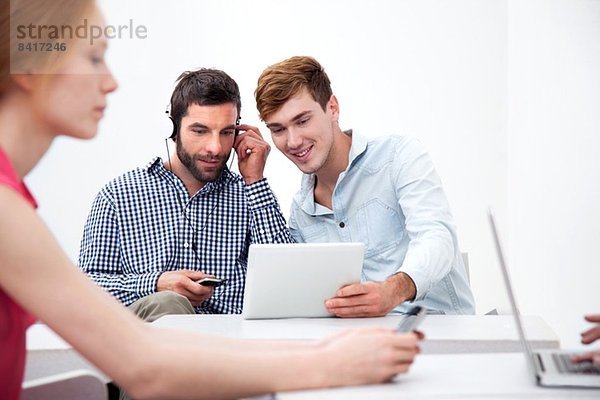 Zwei männliche Kollegen mit digitalem Tablett