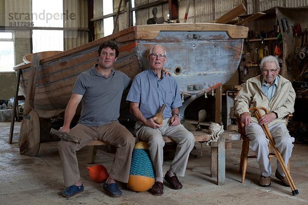 Gruppenportrait von drei Generationen männlicher Bootsbauer