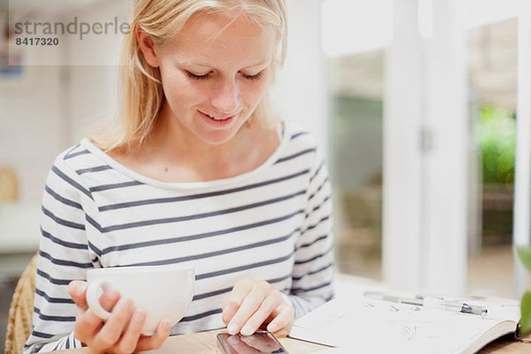 Junge Frau im Café Browsing-Menü